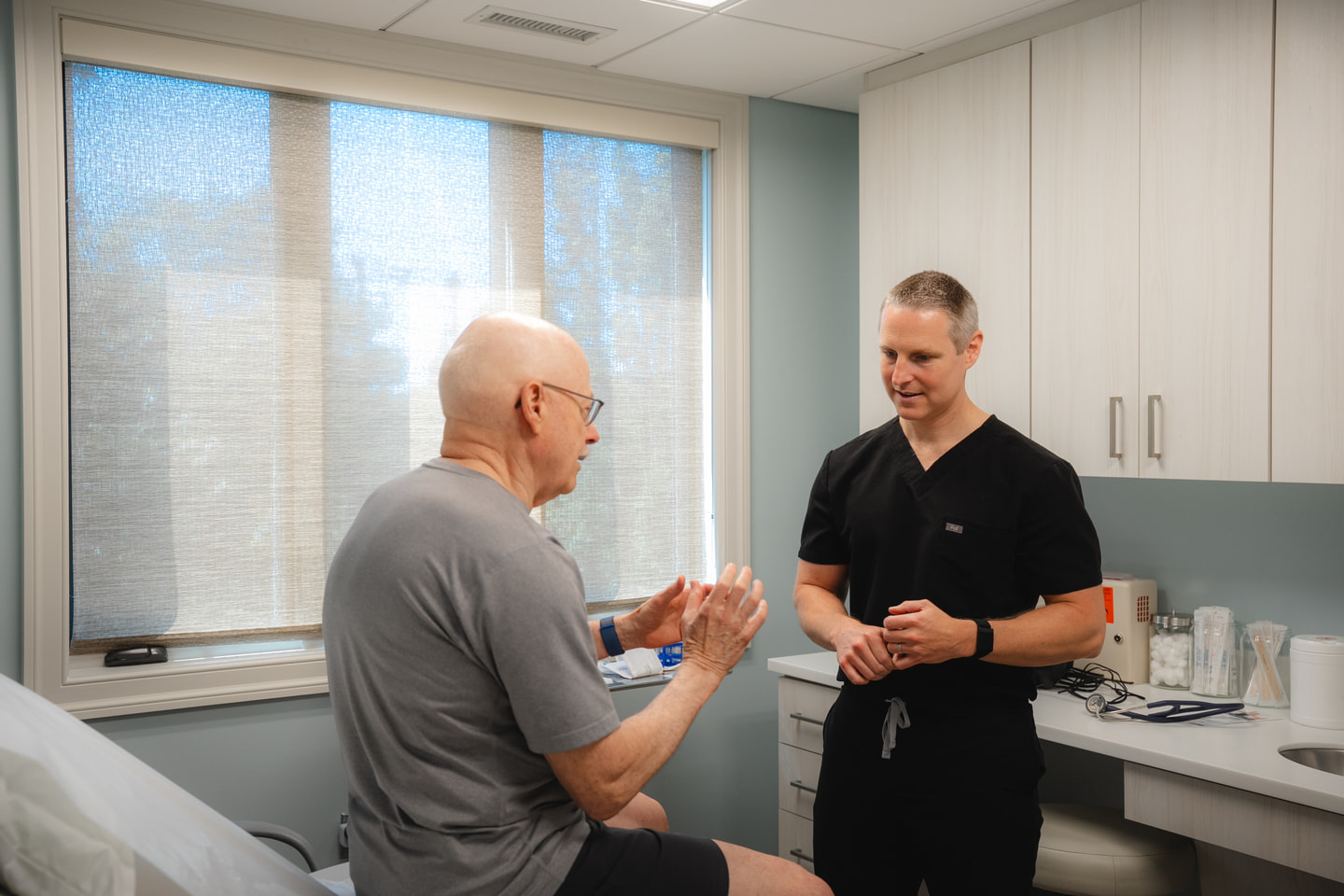 Dr. Schaaf listening during a conversation in an examination room.